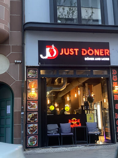 Photo of a döner-shop with the sign above the door saying "JUST DÖNER" and a smaller "döner and more" below.
